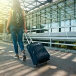 Woman Walking on Pathway While Strolling Luggage