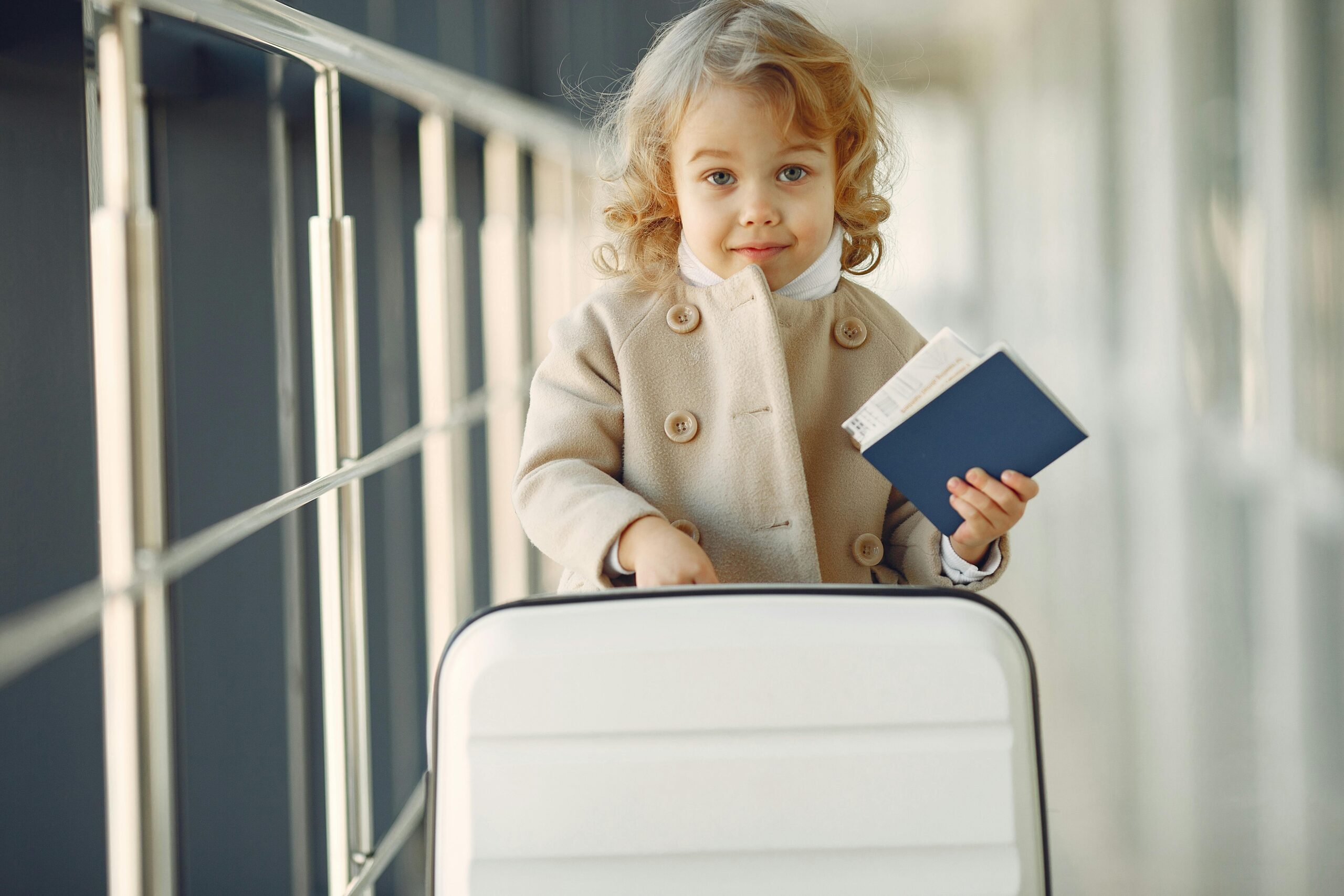 Cute little girl with suitcase and passport